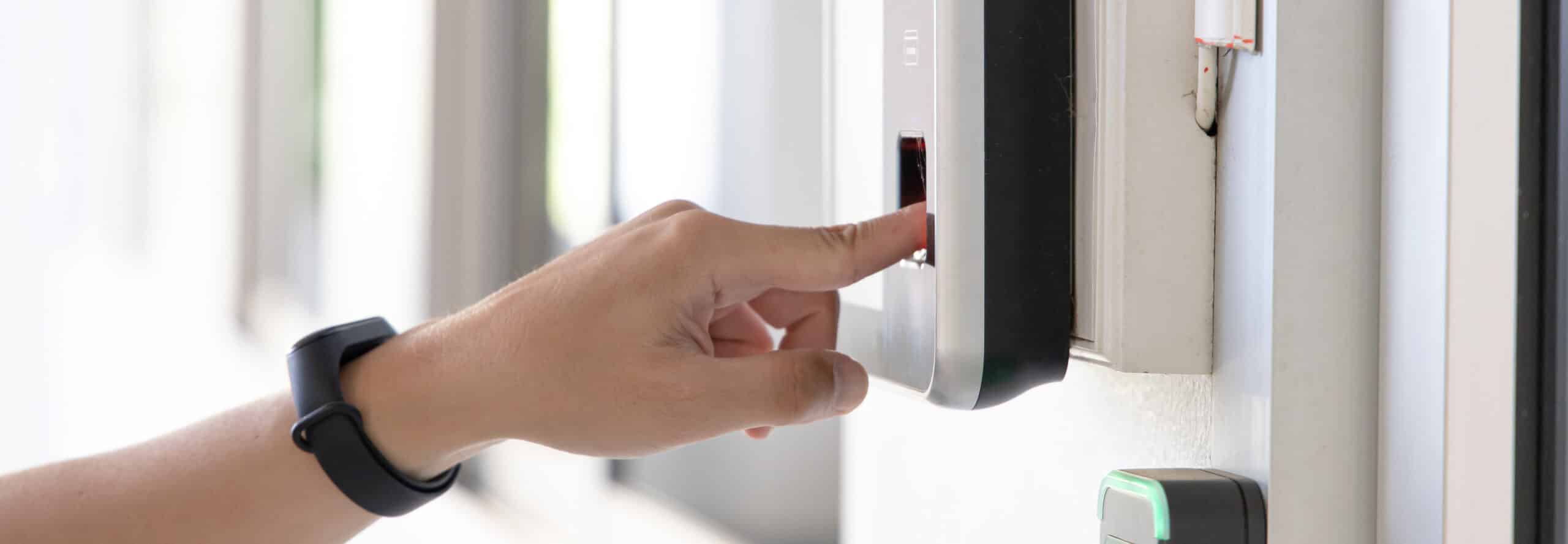 Employee pressing a finger on an attendance fingerprint scanner